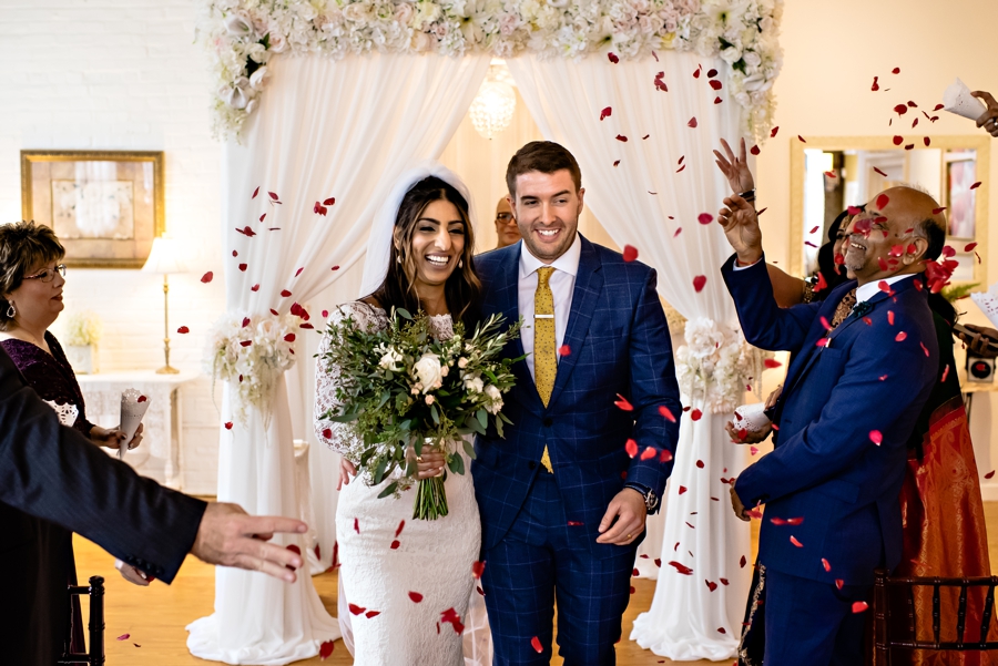 A Bride and Groom walk through rose pedals right after their ceremony at The Philadelphia Wedding Chapel.